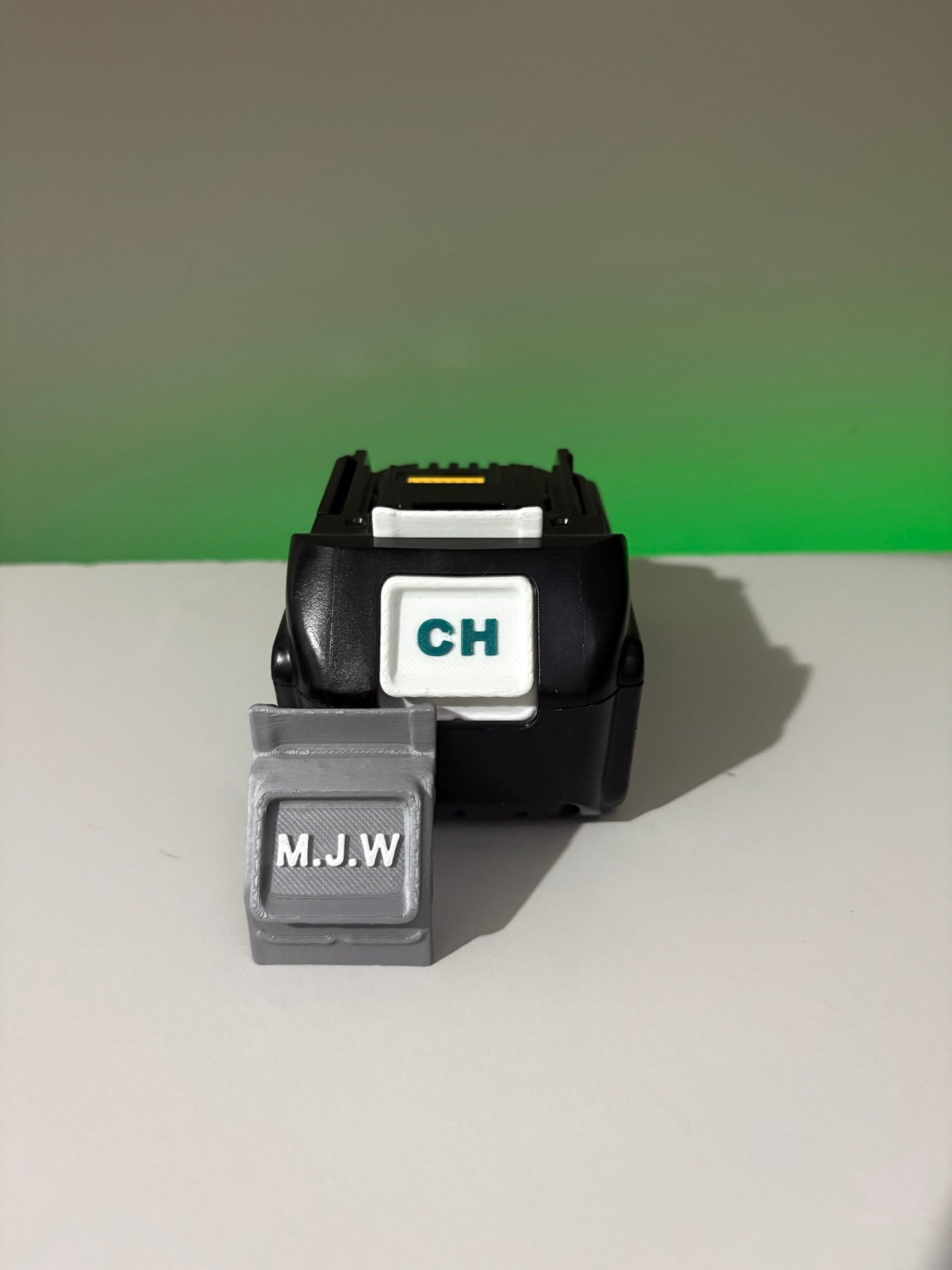Custom 3D printed battery labels with text on Milwaukee and Makita batteries