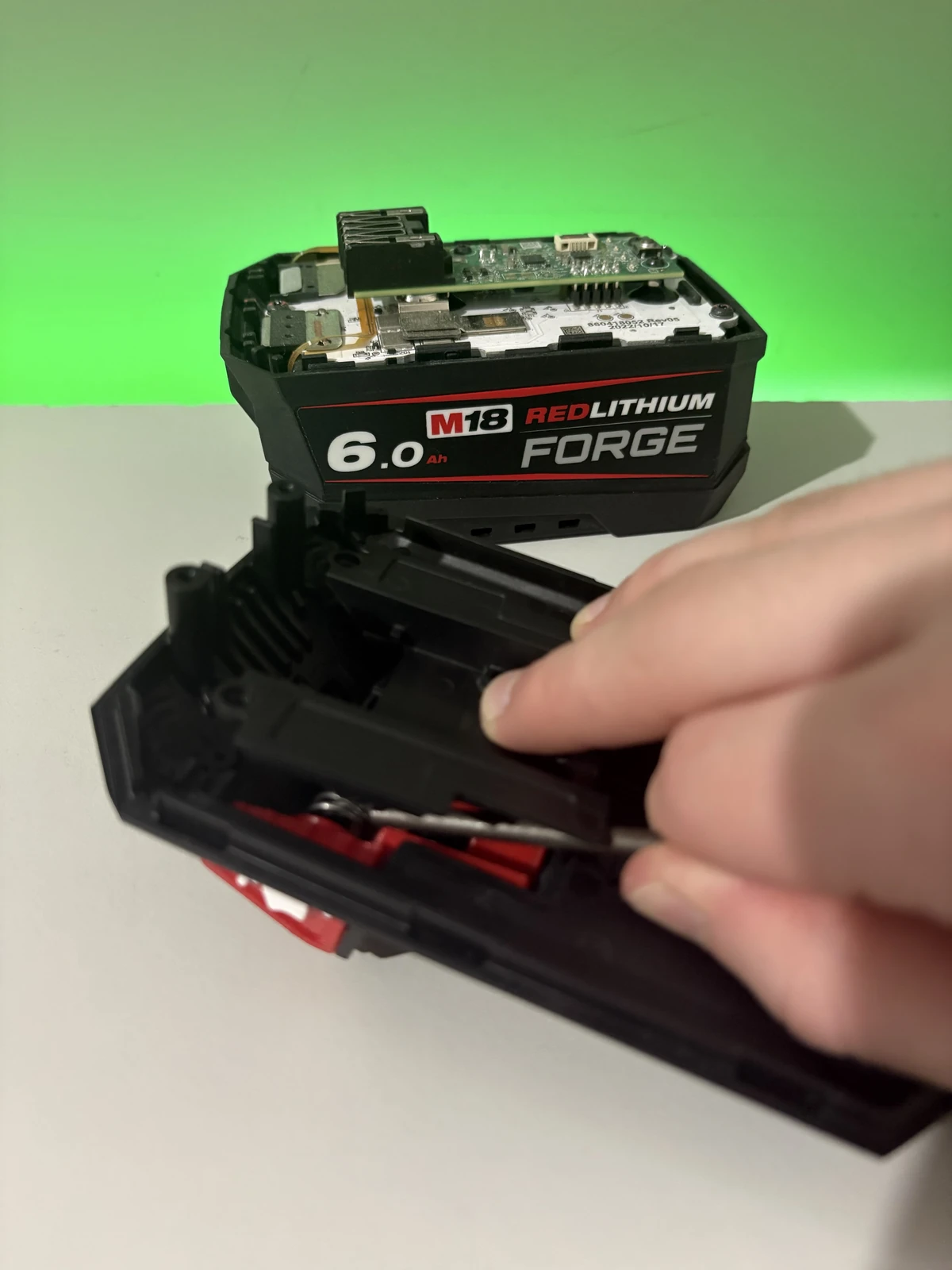 Using a loose drill bit to hold the second spring inward while fitting the Milwaukee retaining plate